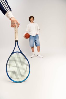 Genç bir çift, tenis raketi ve basketbolla spor ve stile olan sevgilerini sergiliyor..