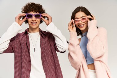 Genç bir çift, modaya uygun mor güneş gözlükleriyle neşeli bir anın tadını çıkarıyor..