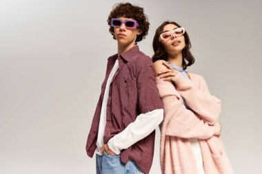 Kendine güveni tam genç bir çift, modaya uygun kıyafetler ve şık güneş gözlükleri takıyorlar, aşk saçıyorlar..