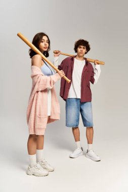 Sevgi ve güven saçan, yaratıcı bir stüdyoda beyzbol sopalarıyla poz veren şık bir çift..