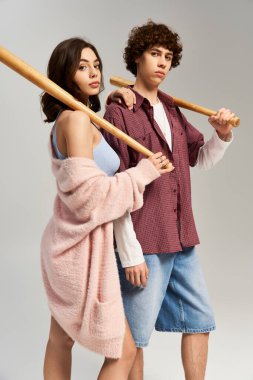 Modaya uygun genç çift, beysbol sopalarıyla birlikte moda tarzlarını ve aşklarını sergiliyorlar..