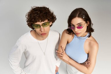 Genç çift, modaya uygun bir ortamda eşsiz güneş gözlükleriyle hava atıyor..