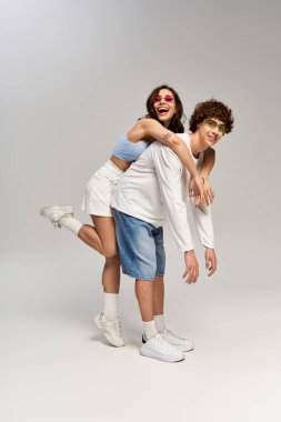 Şık bir çift, modaya uygun kıyafetlerle neşeyle şakalaşır..