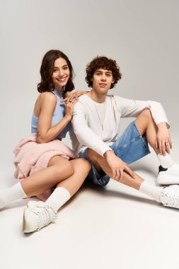 Genç adam ve kadın çağdaş bir stüdyoda rahatça otururken aşk ve tarz yayıyorlar..