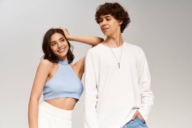 Tarz sahibi genç bir çift, modaya uygun kıyafetler giyip, aşkı ifade ederken neşeli bir anı paylaşıyor..