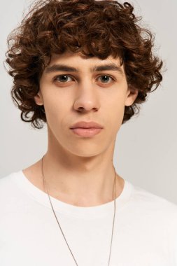 Arkaplanda beyaz tişörtlü çekici bir adam..