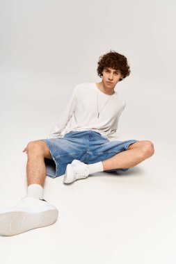 Şık giyinen yakışıklı moda belirleyicisi dingin beyaz arka planda.