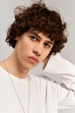 Beyaz arka planda sade giyinmiş şık genç bir adam..