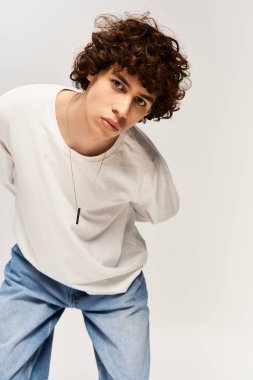 Gösterişli beyaz arka planda şık giyinmiş çekici genç bir adam..