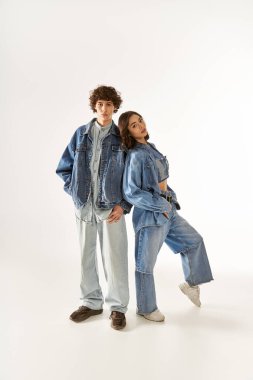 Parlak bir stüdyoda aşk saçan şık bir çift şık kot giysiler içinde parlıyor..