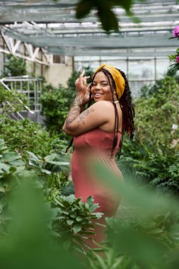 Gür bir serada örgülü güzel bir kadın, mutlu bir anın tadını çıkarıyor..