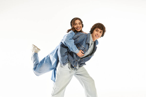 A loving couple shares a joyful experience, showcasing their stylish denim attire and affection.