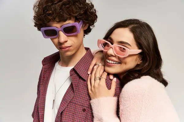 Şık bir erkek ve kadın kucaklaşır, sevgi ve neşe saçar, moda kıyafetlerini sergilerler..