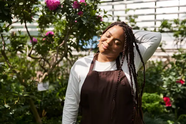 Mutlu bir bahçıvan, canlı bir serada filizlenen bitkilerle ilgilenmekten zevk alır..