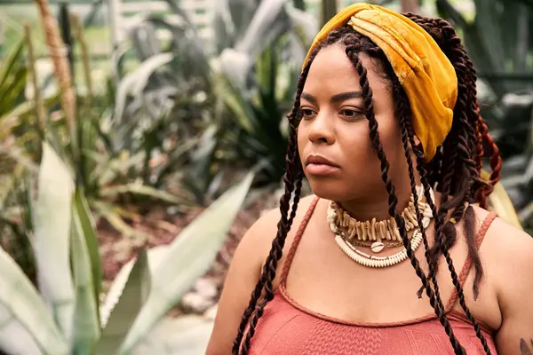 Kendine güvenen siyah bir kadının etrafındaki yeşil elbiseye hayran olduğu huzurlu bir an..