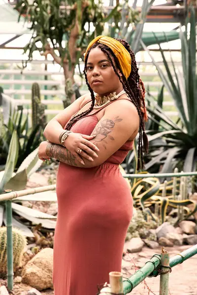 Zarif bir kadın zarif tarzını ve ışıltısını sergileyerek yemyeşil bir yerde poz verir..