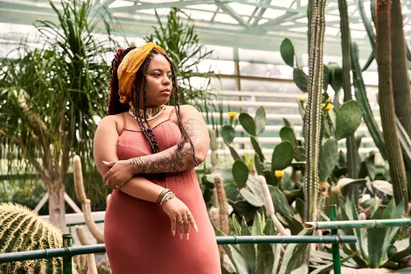 Saçları örülü güzel bir Afro-Amerikalı kadın yemyeşil ve dingin anların tadını çıkarıyor..