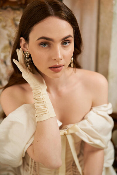 Изящная молодая женщина, украшенная изысканным винтажным платьем очаровывает своим очарованием..