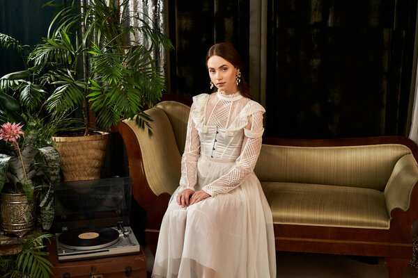 Молодая женщина в винтажном платье элегантно сидит в уютной, полной растений гостиной.