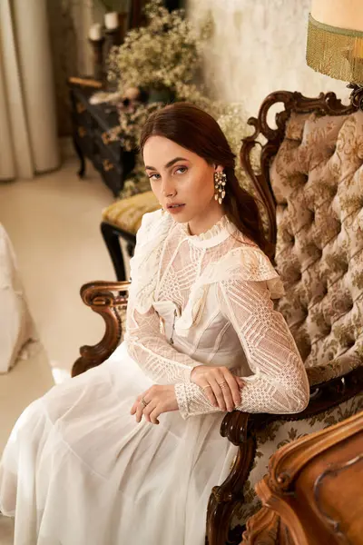 Hoş genç bir bayan zarif bir şekilde oturmakta, şık bir odada klasik moda sergiliyor..