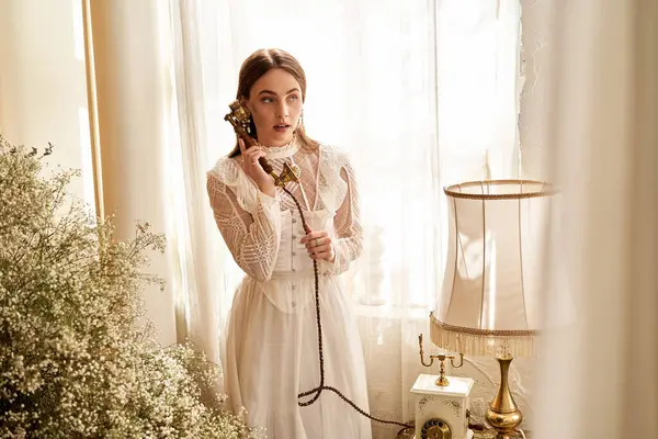 Genç bir kadın elinde bir retro telefon tutuyor, yumuşak güneş ışığı ve narin bir dekorla yıkanmış..