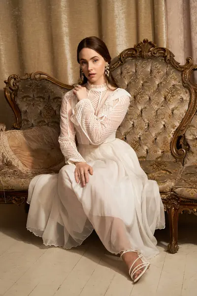 Zarif genç bir kadın zarif bir şekilde oturuyor, baş döndürücü bir elbise giyiyor, güzelliği somutlaştırıyor..