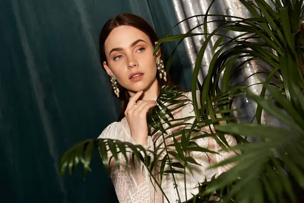 Güzel genç kadın, zengin bitkiler ve yumuşak ışıklarla çevrili eski moda kıyafetleri kutluyor..
