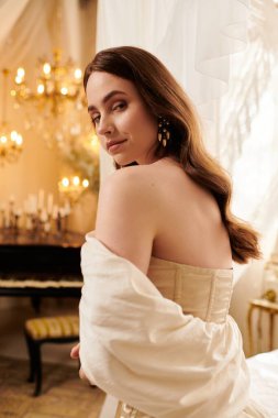 Güzel genç bir kadın, zarif ve zarif bir ortamda eski bir elbise sergiliyor..