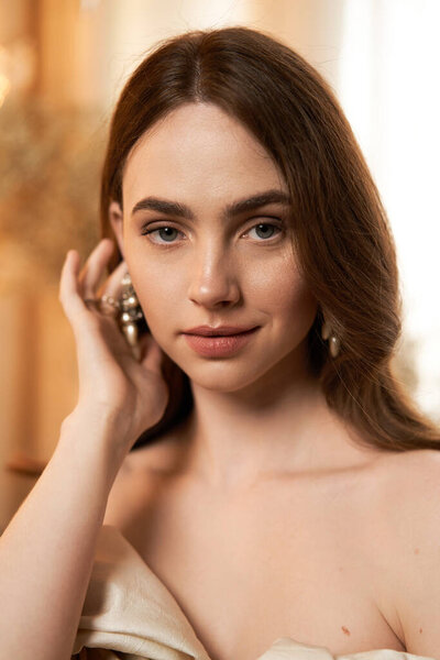 Блаженная молодая женщина изящно позирует, демонстрируя винтажное платье при мягком освещении.