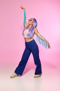 Renkli saçlı şık bir kadın neşeli, kendine güvenen bir şekilde poz verir..