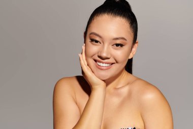 Zarif kadın zarif bir şekilde poz verirken çarpıcı gülüşünü ve şık tarzını ön plana çıkarıyor..