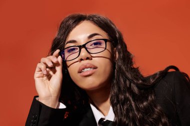 Kendine güvenen genç bir kadın, kendine has tarzını ve akademik havasını çarpıcı gözlüklerinde sergiliyor..