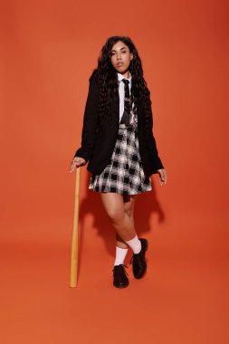 Kendine güvenen öğrenci, sopayla poz verirken kendine has moda tarzını sergiliyor..