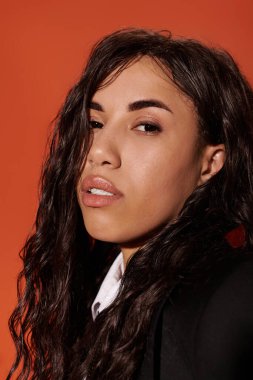 Genç bir öğrenci kendine güvenerek eşsiz tarzını sergiliyor. Zengin kıvırcık saçları ve zarif bir görünüşü var..