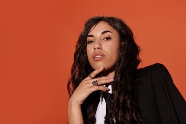 Siyah ceketli ve kravatlı genç bir kadın nazikçe çenesini eline dayar. Yukarıya bakıyor..