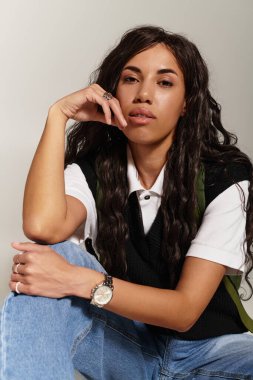 Güzel genç öğrenci kendine güvenen, modaya uygun ve düşünceli bir ifade takınıyor..