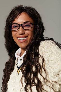 Rahat bir süveter içindeki neşeli öğrenci çalışmalarından zevk alırken pozitif ışıldıyor..