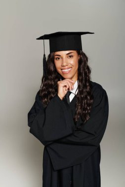 Genç bir kadın mezuniyet elbisesiyle gururlu ve mutlu bir anı yakalıyor..