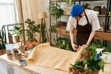 Genç bir adam yeşilliklerle dolu canlı bir stüdyoda bitki nakletmeye odaklanmış..