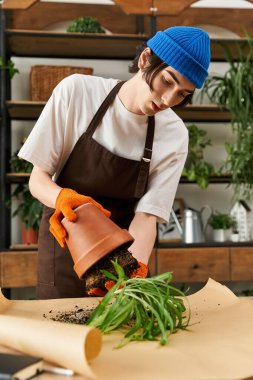 Genç adam canlı yeşillikleri dikkatlice naklederken aynı zamanda bir stüdyoda bitkilere olan sevgisini arttırıyor..