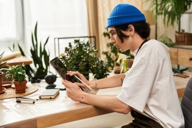 Yakışıklı bir genç, sevgi dolu bir stüdyoda bitki naklediyor..