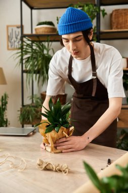 Genç adam, doğaya olan sevgisini göstermek için, davet edilen bir stüdyoda bitki saklama eğilimindedir..