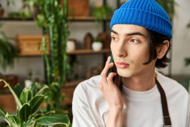 Doğayla iç içe geçmiş şık giyinmiş, telefonla konuşan genç bir adam..