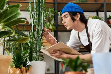 Genç adam bitkilere özen gösterir ve gelişmelerini canlı bir stüdyo ortamında not eder..