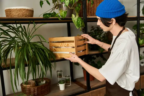 Yakışıklı genç adam güneşli bir günde sıcacık bir stüdyoda bitki naklediyor.