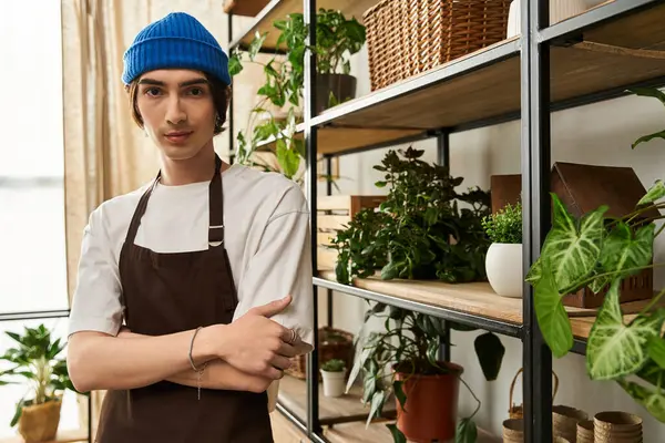 Genç adam stüdyo çalışma alanını özenle düzenlerken yeşil bitkileri nakletmeye odaklanmış.