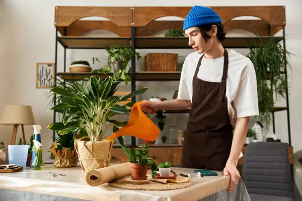 Önlüklü genç adam atölyesinde çiçek naklederken dikkatli bir şekilde çiçeklerle ilgileniyordu..