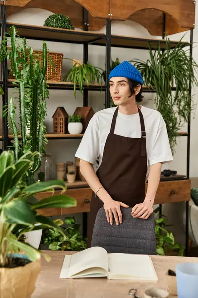 Genç adam şık bir iç bahçe ortamında canlı bitkiler naklediyor.