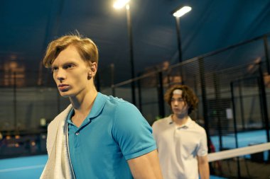 İki genç sporcu atletizm ve kararlılıklarını sergileyerek Padel oynamaya hazırlanıyorlar..