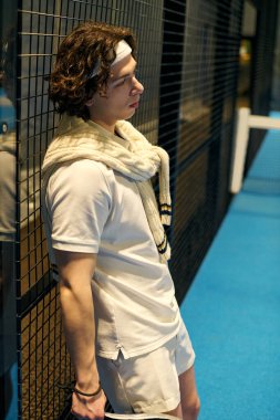 Genç bir sporcu, canlı bir padel kortunda heyecanlı bir maç sırasında ara veriyor..